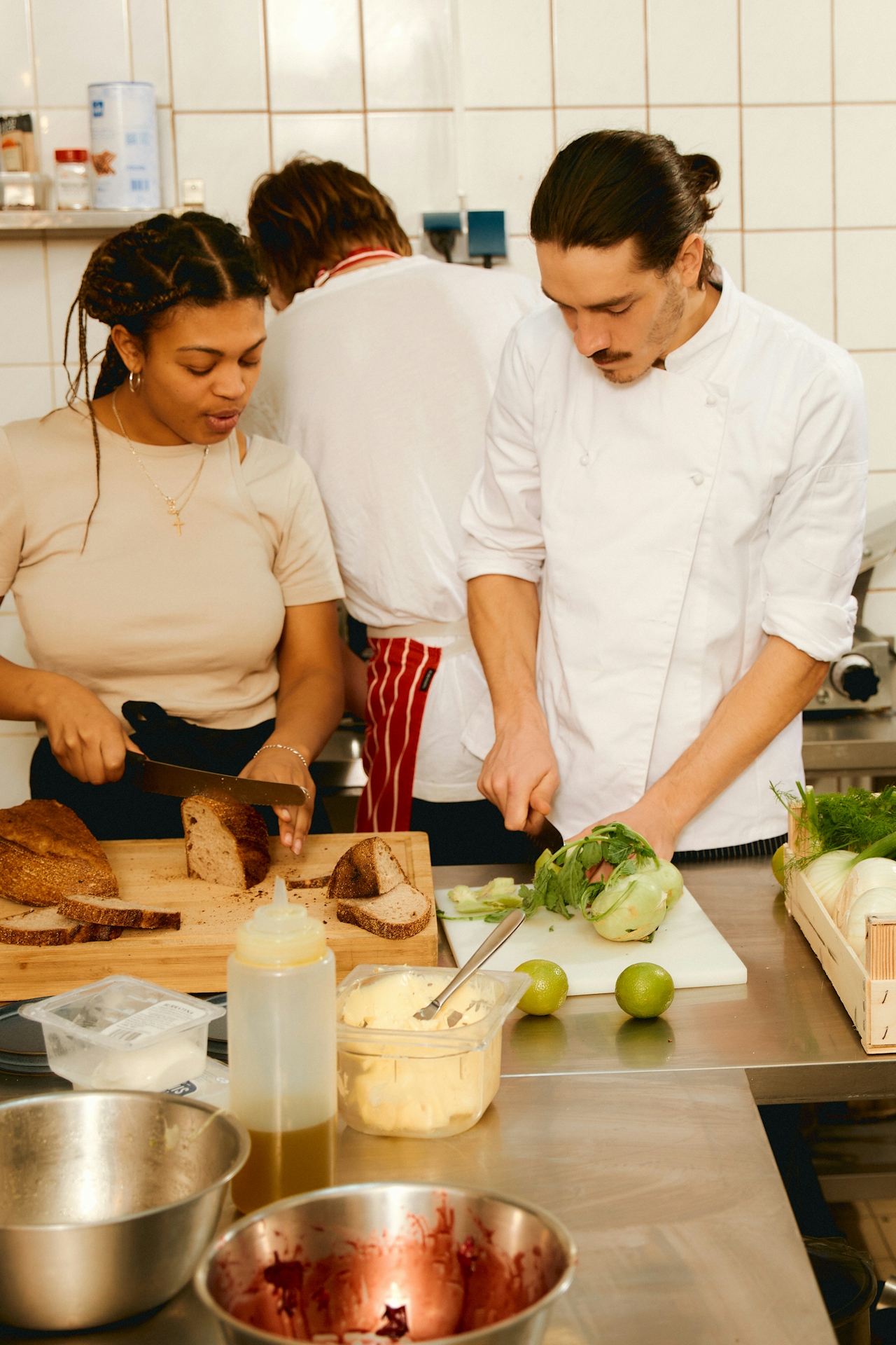 Coworkers prepping food side-by-side in a bright kitchen — collaborative everyday work.