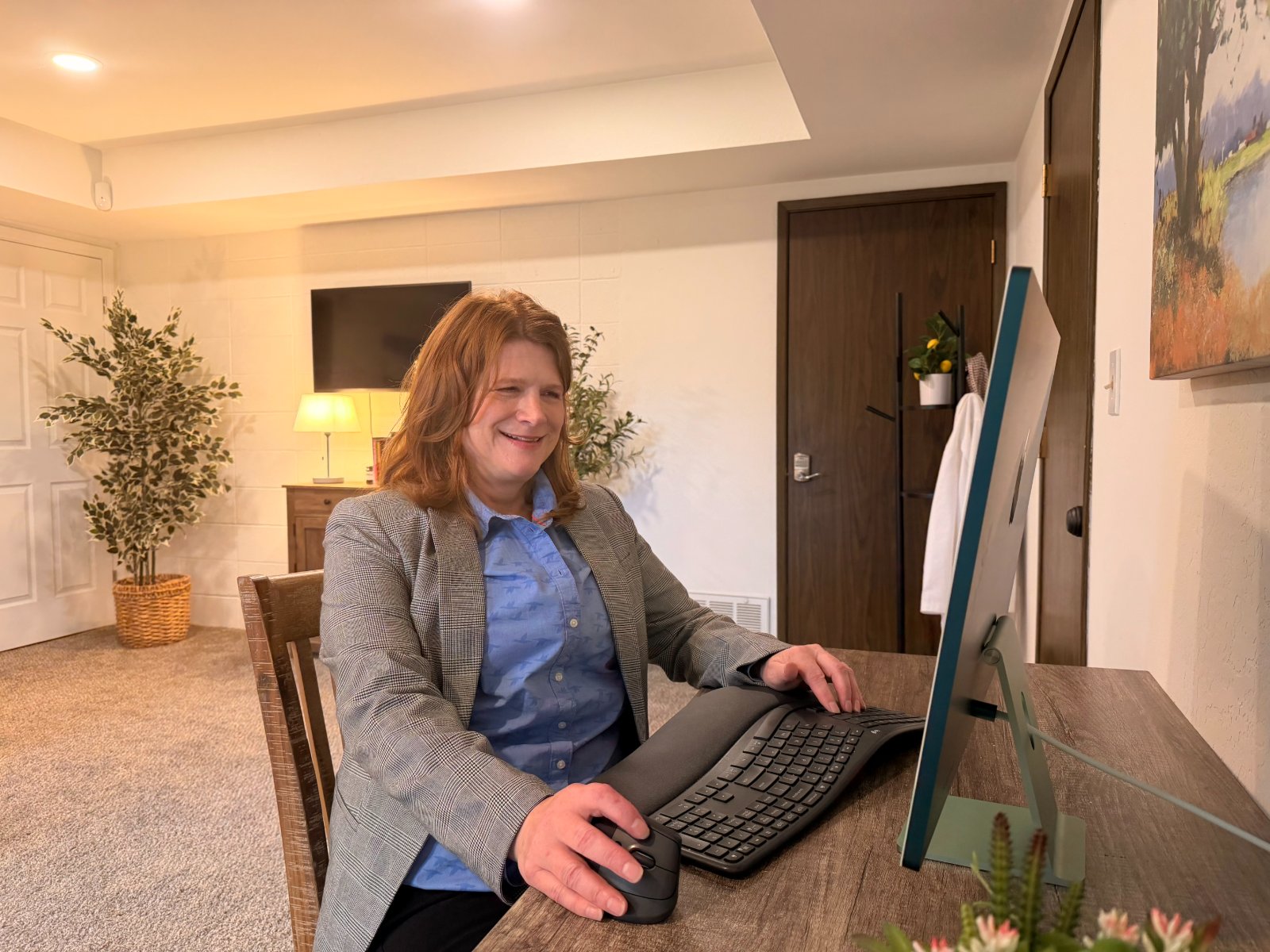 Lavena McCullum, PMHNP-BC, smiling during a telehealth video visit at her desk — MindHealth Psychiatry.