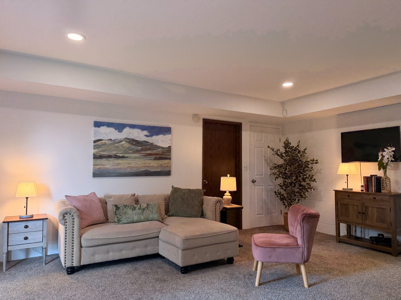 A warm, comfortable seating area inside a MindHealth Psychiatry in-person office — soft lighting, calming artwork, and a relaxed sofa.